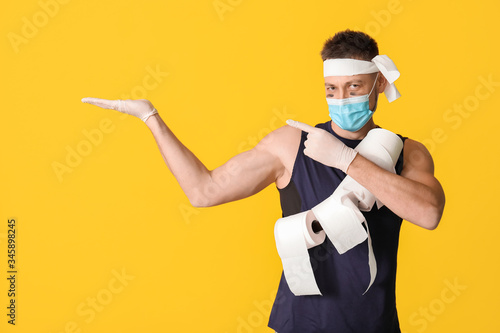 Funny man with toilet paper showing something on color background. Concept of coronavirus epidemic