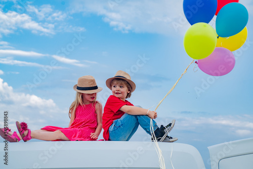 Little girl and boy outdoor with balloons. Happy day. Happy childhood. Kids smiling. Has happy. International childrens day.
