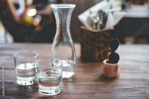 Glasses of water on a shabi wooden table. Trendy serving in the stylish hipster restaurant.