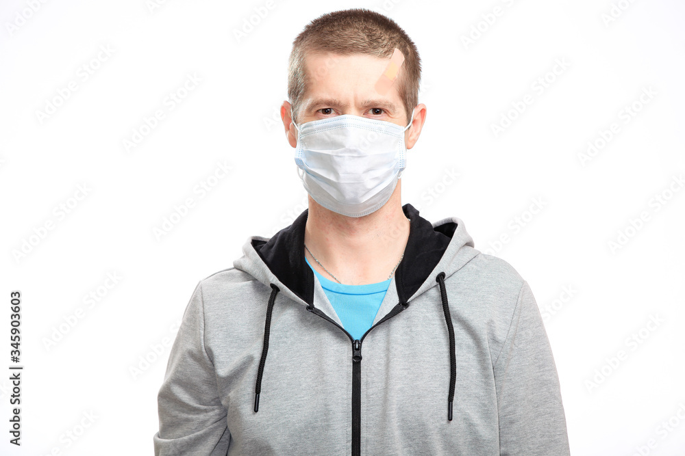 A sports confident wounded man with a medical mask and a Band-Aid on his head from the injury, sportswear, smiling, looking at the camera. Isolated A sports confident wounded man with a medical mask and a Band-Aid on his head from the injury, sportswear, smiling, looking at the camera. Isolated