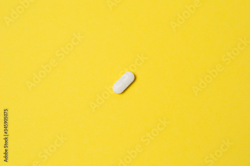 White pill on a yellow background, isolate, with place for text