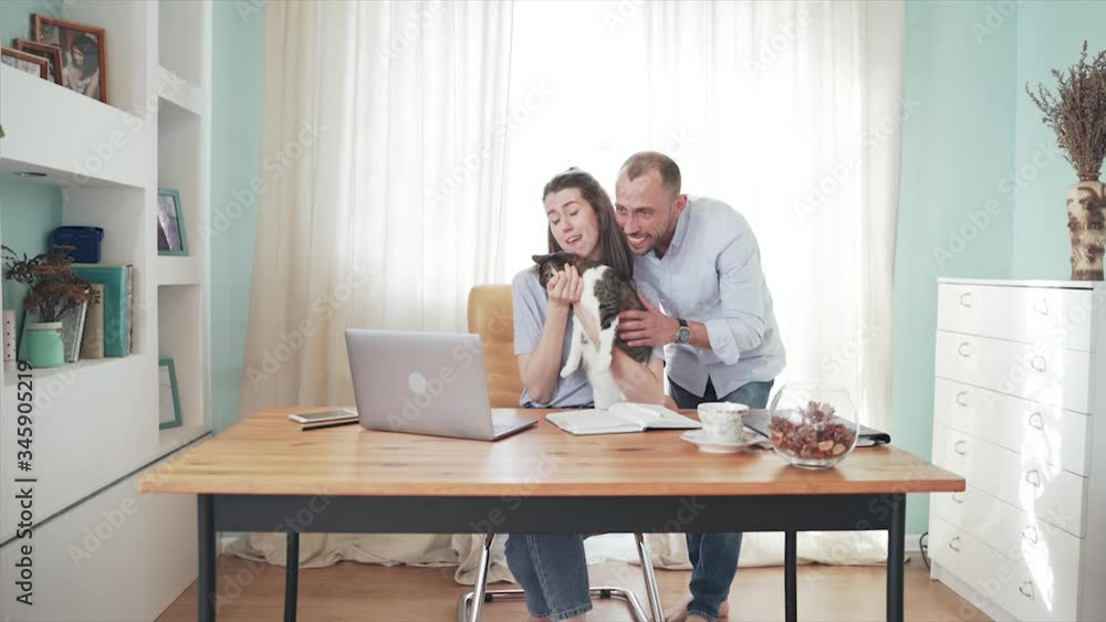 A woman and man communicates online. A woman is talking and stroking a cat. Protection of animals. Happy marriage. Remote work. Family on self-isolation Home office. Quarantine Epidemic. Funny cat. A woman and man communicates online. A woman is talking and stroking a cat. Protection of animals. Happy marriage. Remote work. Family on self-isolation Home office. Quarantine Epidemic. Funny cat.