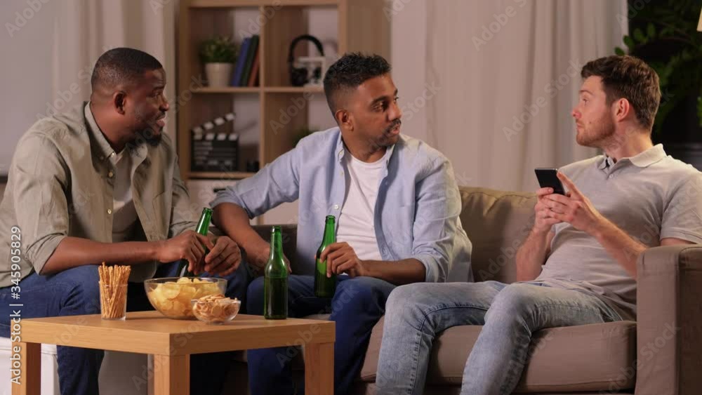 friendship, leisure and people concept - male friends drinking beer and talking at home at night friendship, leisure and people concept - male friends drinking beer and talking at home at night
