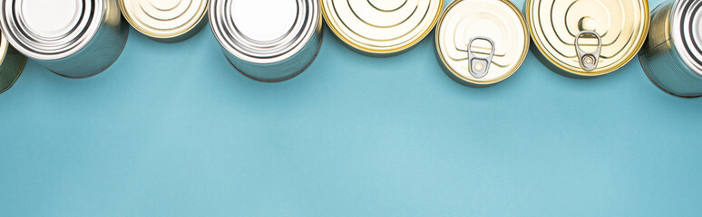 top view of cans on blue background with copy space, food donation concept