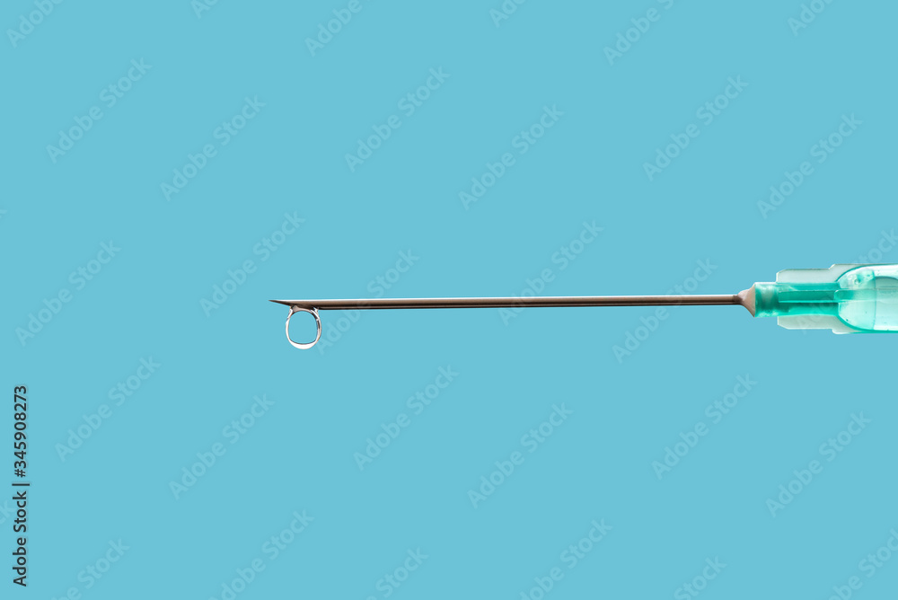 Medical syringe with a needle at the end of the drop. Medical syringe with a needle at the end of the drop.