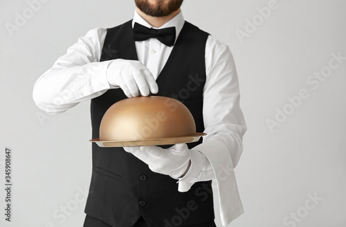 Male waiter with tray and c...