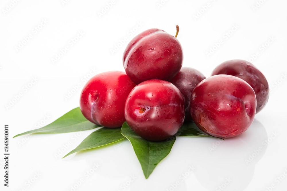 plums with plum leaves on a white background plums with plum leaves on a white background