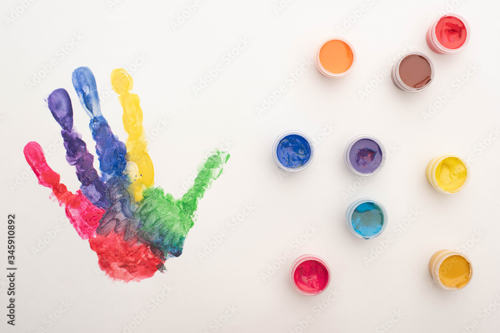 top view of colorful handprint and paints on white for World Autism Awareness Day top view of colorful handprint and paints on white for World Autism Awareness Day