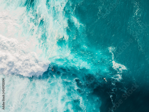 Wave with foam in blue ocean. Aerial view of barrel waves. Top view