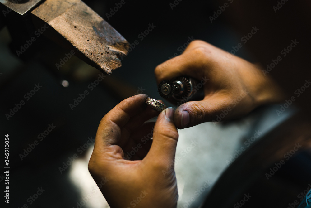Fototapeta premium Master of jewelry while working on making a gold ring. Top view. 