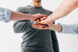 Cropped view of coworkers holding hands in office