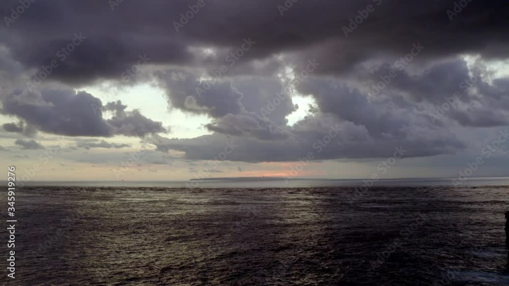 Sunset at Atuh Beach with cliff home in Nusa Penida island looking at Bali Indonesia in the horizon, Aerial dolly out reveal shot Sunset at Atuh Beach with cliff home in Nusa Penida island looking at Bali Indonesia in the horizon, Aerial dolly out reveal shot