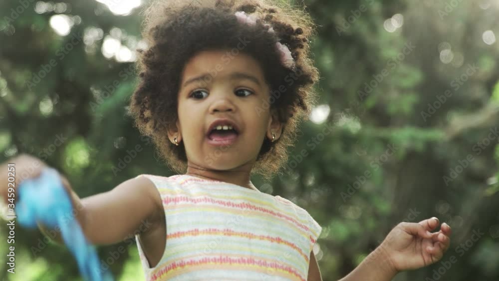 Little african-american girl plays with soap bubbles in the park. Little african-american girl plays with soap bubbles in the park.