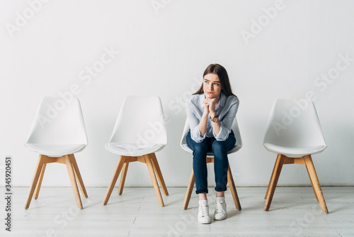 Thoughtful girl waiting for job interview in office