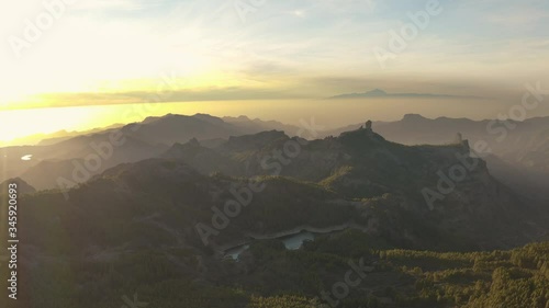 Pico de las nieves, roque nublo, gran canaria, with the teide, teneriffa beautiful cinematic panorama drone aerial fly away shot at sunset golden hour 30p photo