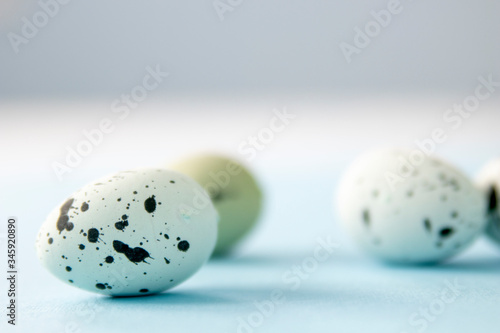 Side view of painted wooden robin eggs with selective focus and negative space for copy