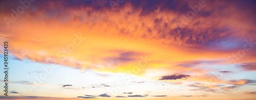 Vivid wide view photo of cloudy sky during sunset, with magenta, cyan, orange and purple colors of the sky. Nature background