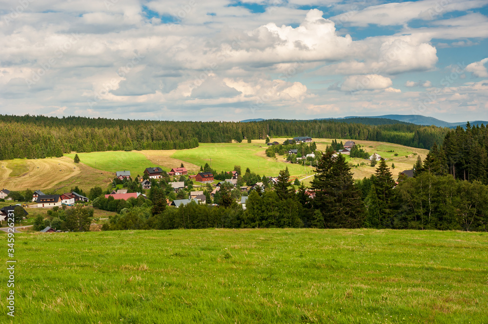 Sunset on fileds and forests. Evening sunbeams on meadow. Warm sun light in villages of Sumava, Bohemian Forest, Böhmerwald, Czech Republic. Sunset on fileds and forests. Evening sunbeams on meadow. Warm sun light in villages of Sumava, Bohemian Forest, Böhmerwald, Czech Republic.