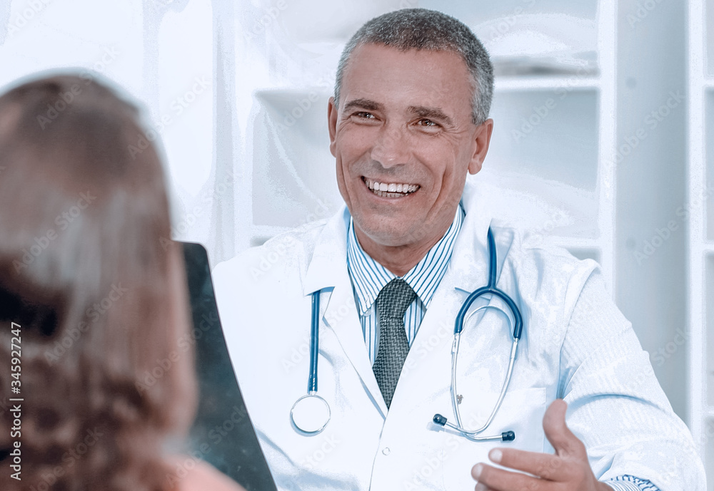 Doctor talking to patient sitting at the table Doctor talking to patient sitting at the table