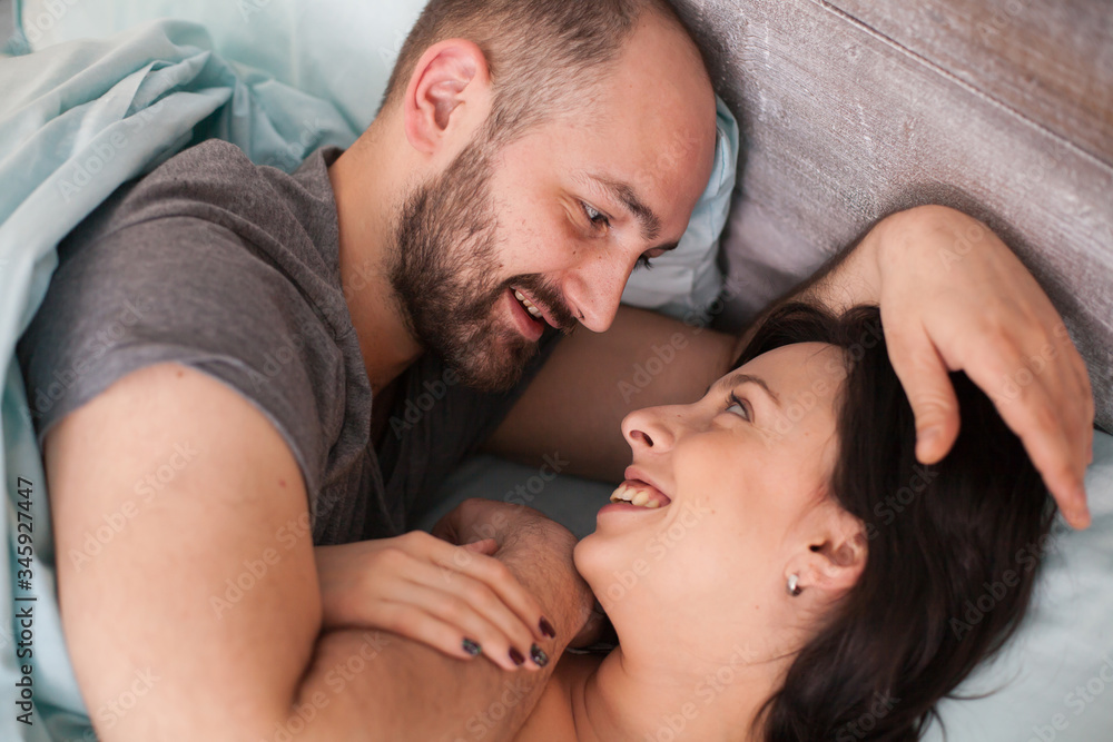 Beautiful loving couple in the morning wearing pajamas. Wife smiling. Beautiful loving couple in the morning wearing pajamas. Wife smiling.