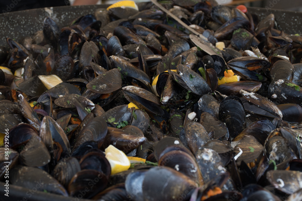 Fresh mussels in shells at steam pan. Seafood barbecue outdoors.