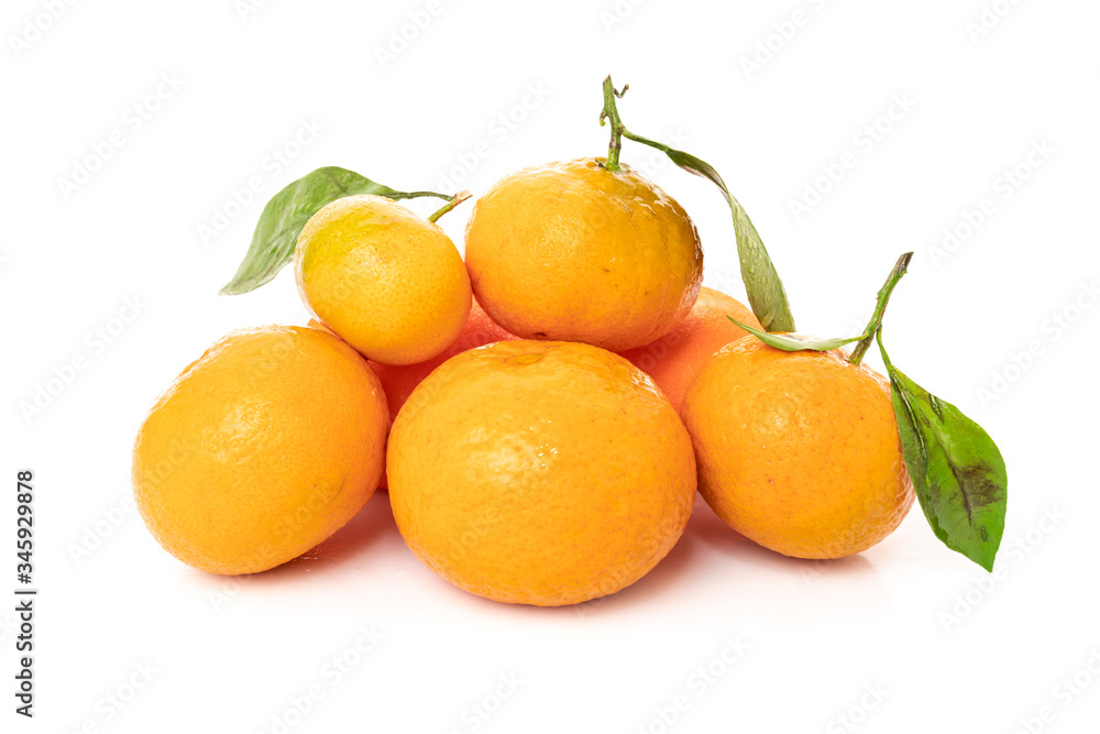 Ripe mandarines with leaves close-up on a white background Ripe mandarines with leaves close-up on a white background