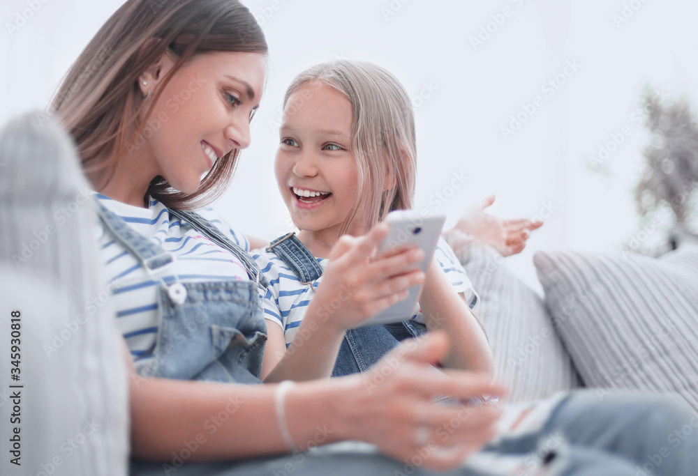 close up.happy mom and her daughter are watching videos on smartphone close up.happy mom and her daughter are watching videos on smartphone