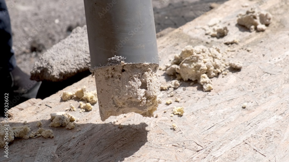 Fototapeta premium A plumber removes solid deposits from grease and debris from a plastic sewer pipe.