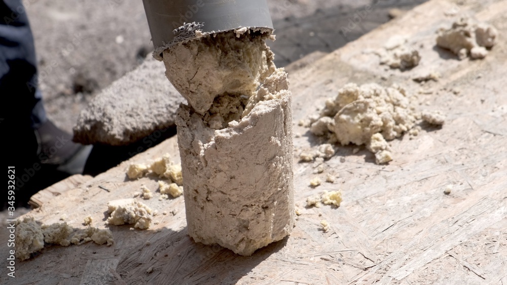 Fototapeta premium A plumber removes solid deposits from grease and debris from a plastic sewer pipe.