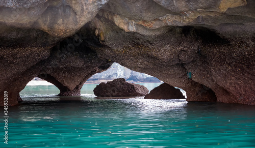 Double-exit cave with turquoise water below limestone rocks
