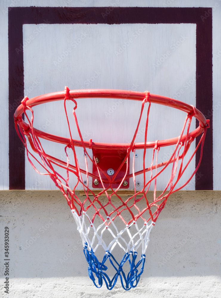 New basketball hoop with red, white and blue net mounted on outdoor backboard. New basketball hoop with red, white and blue net mounted on outdoor backboard.