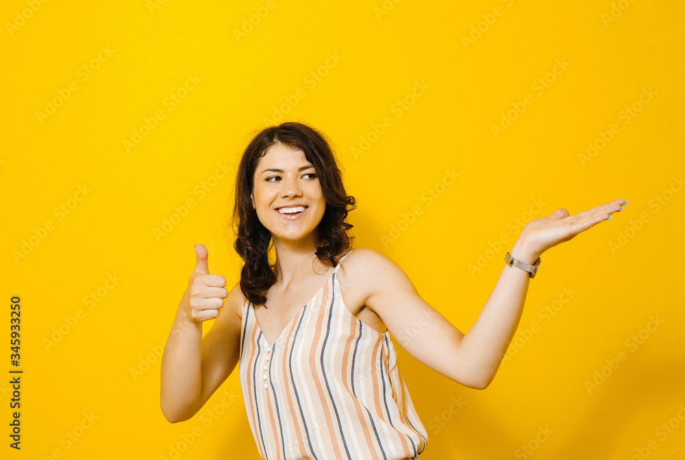 Image of excited young asian woman standing isolated over yellow background make winner gesture. Image of excited young asian woman standing isolated over yellow background make winner gesture.