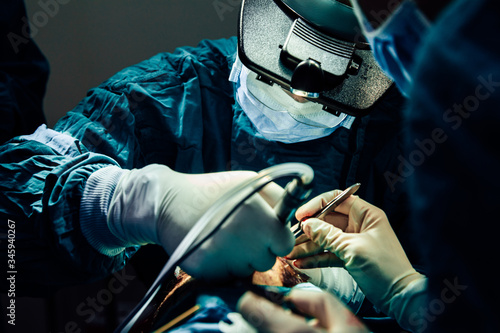 Close up doctor with surgical tools making surgery in the operating room, baldness treatment, hair transplant photo