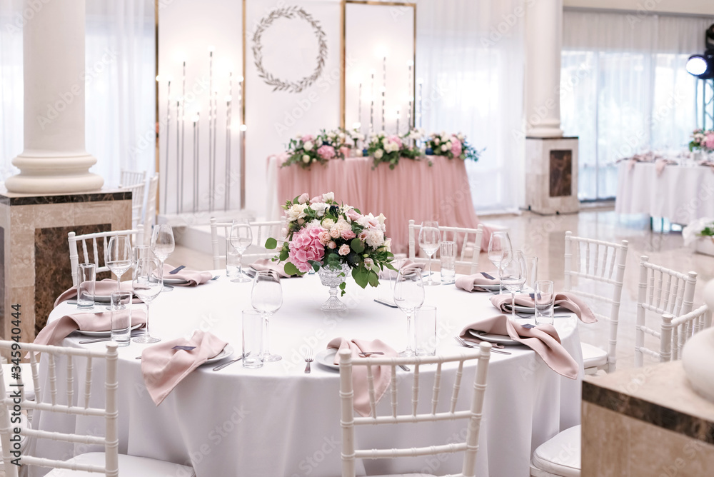 The luxurious round table for the wedding lunch is decorated with flowers and stylish dishes. Beautifully organized event - served festive tables ready for guests The luxurious round table for the wedding lunch is decorated with flowers and stylish dishes. Beautifully organized event - served festive tables ready for guests