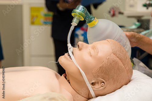 Demonstrating CPR (Cardiopulmonary resuscitation), hand holding a ambu bag on dummy patient, first aid training, CPR medical procedure photo