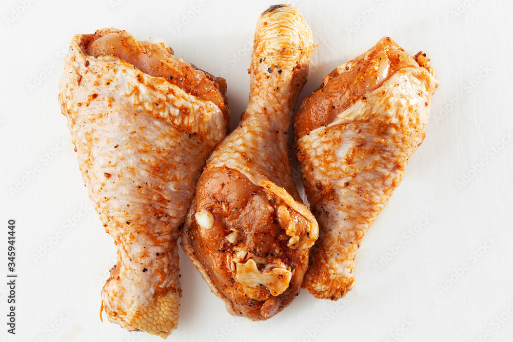 Raw drumsticks on white background. Chicken legs. Raw chicken marinated legs. Top view. Food Background. Cooking content. Uncooked meat. Meat shop concept. Raw drumsticks on white background. Chicken legs. Raw chicken marinated legs. Top view. Food Background. Cooking content. Uncooked meat. Meat shop concept.