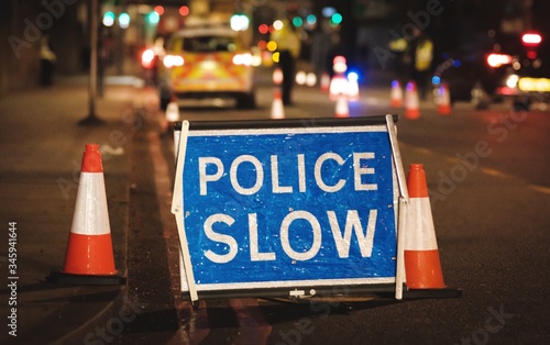 police slow sign on street at night lights bokeh london united kingdom