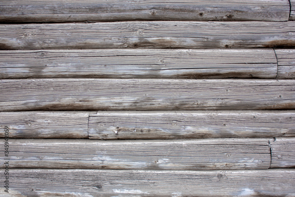 Obraz premium The wall of an old wooden house of logs. Natural wood, rough texture.
