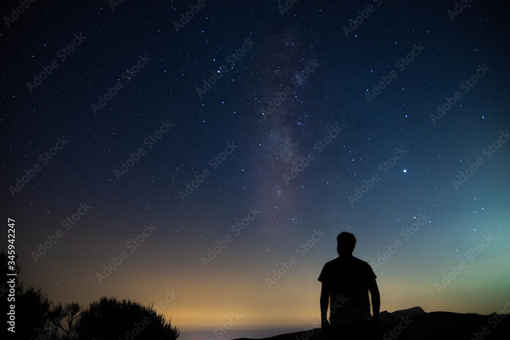 Blurred silhouette of a man observing the starry sky with the milky way Blurred silhouette of a man observing the starry sky with the milky way