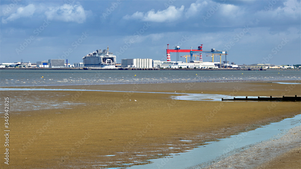 Fototapeta premium Saint Nazaire seen from of the beach at low tide of Saint Brevin les Pins in Pays de la Loire region in western France