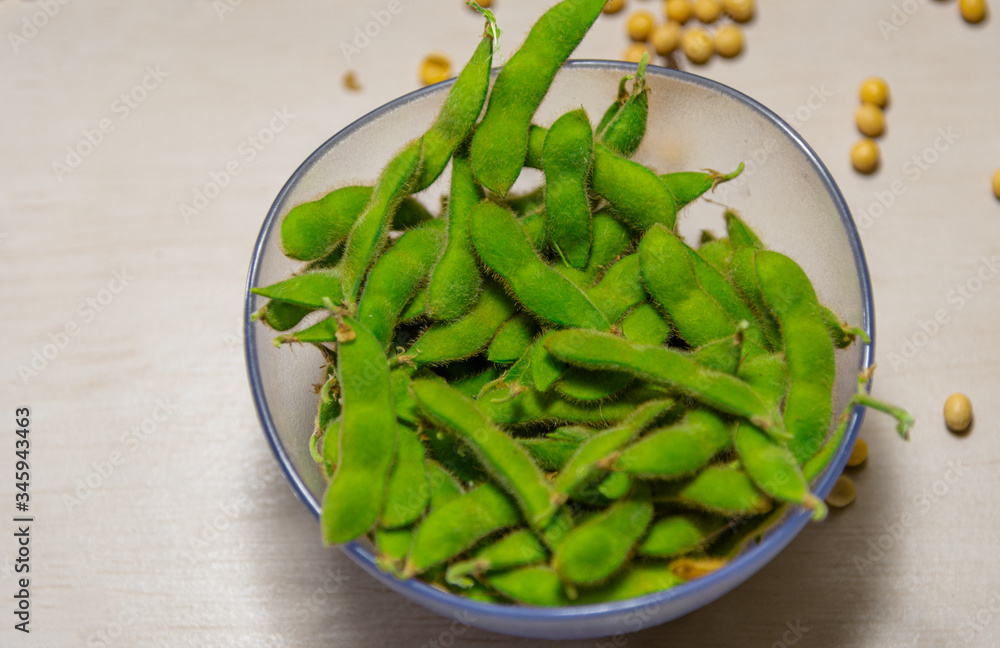 Bowls with soy beans and pods (glycine max) on light background Bowls with soy beans and pods (glycine max) on light background