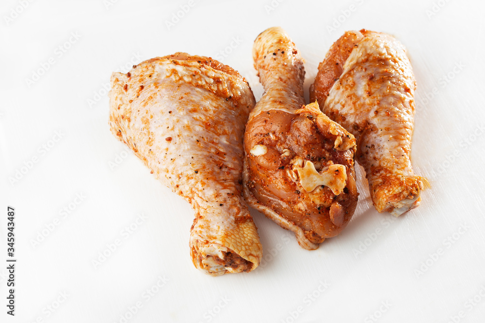 Raw drumsticks on white background. Chicken legs. Raw chicken marinated legs. Top view. Food Background. Cooking content. Uncooked meat. Meat shop concept.