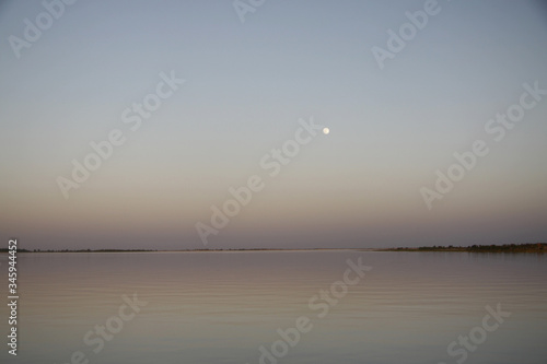 Malowniczy wschód księżyca w pełni na gładkim niebie nad spokojnymi wodami rzeki Niger