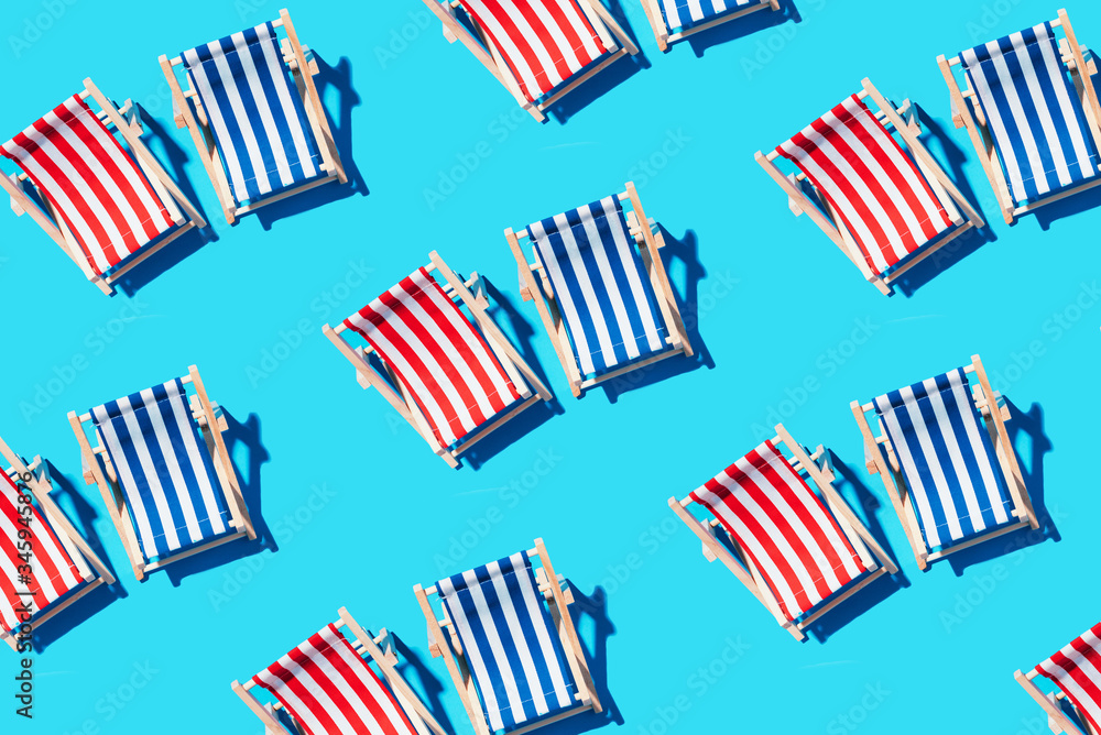 Deck chairs pattern on blue paper background. Flat lay and copy space. Summer travel vacation concept. Creative design, minimal flat lay concept. Minimal composition. Summer time. Deck chairs pattern on blue paper background. Flat lay and copy space. Summer travel vacation concept. Creative design, minimal flat lay concept. Minimal composition. Summer time.