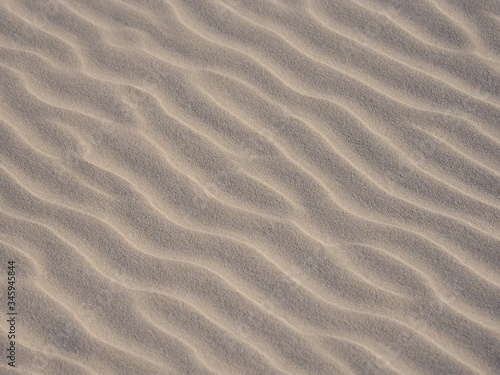Closeup of yellow sand pattern of a beach in the summer. 