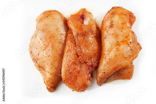 Marinated fillet isolated on a white background. Raw chicken breast fillets. top view with copy space. Flat lay composition with raw chicken breasts. Space for text. Meat shop.