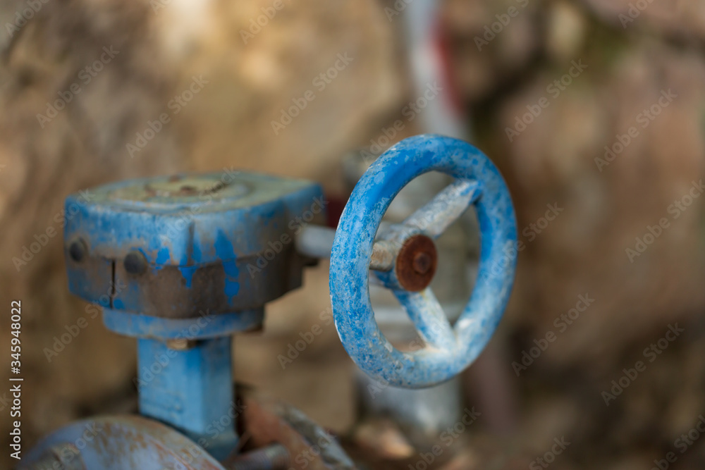 selective focus of Round rusty valve on a pipe in the street selective focus of Round rusty valve on a pipe in the street