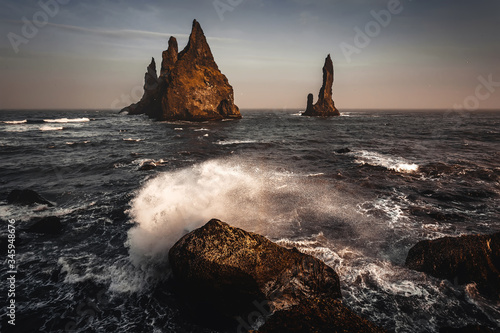 Fantastic nature scenery. Reynisdrangar cliffs near the Vik town. Impressive view on Trolls fingers in Atlantic Ocean during sunset. Iceland the most beautiful and best travel place. Retro style.