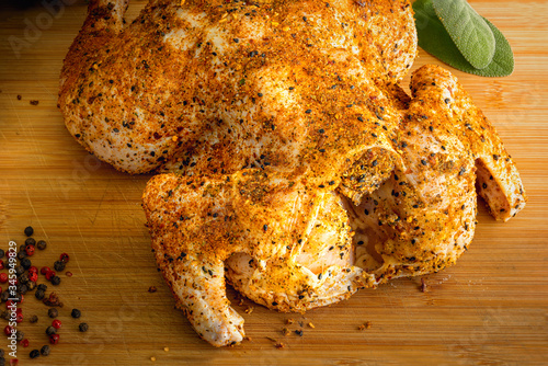 Photography Whole raw chicken rubbed with spices, ready for bbq