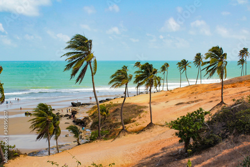 Tourist Beach, Paraipaba in Ceara, Northeast Brazil. Sunny day, weekend, beach holidays, hot summer. Sea and blue sky. Beautiful sunny day. Relaxing nature. Typical vegetation, with palm trees